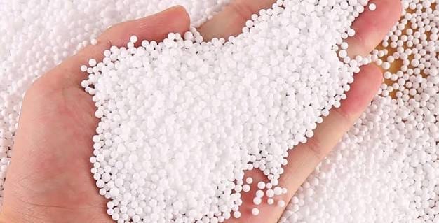 A handful of off-white granular ammonium sulfate