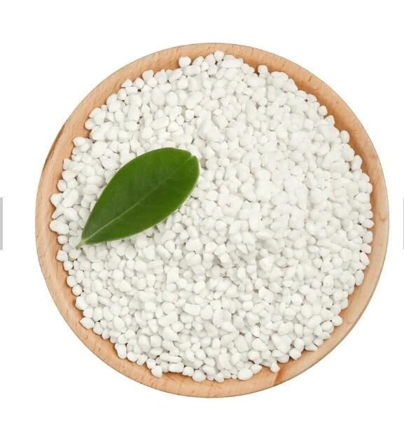 White calcium nitrate granules in a wooden bowl