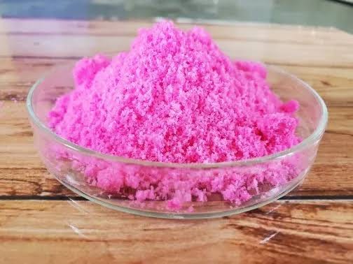 Bright pink water-soluble NPK crystals in a glass dish